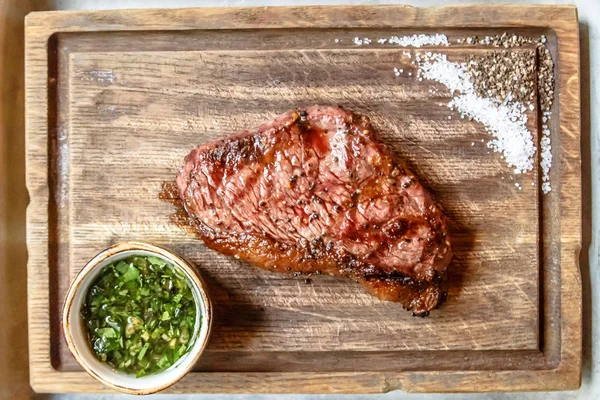 Steak de boeuf repose sur une planche en bois . — Photo