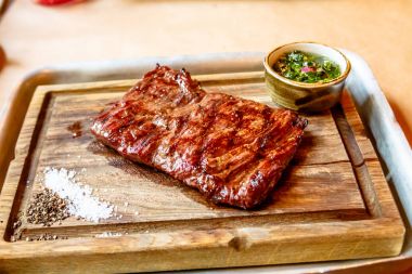 Sığır eti biftek bir ahşap tahta üzerinde yatıyor.