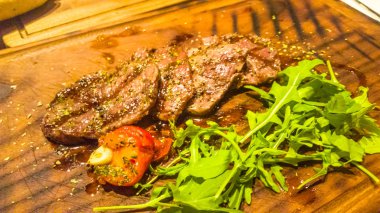 Dilimlenmiş kuzu kızartma ve roka ile bir gemide yalan.