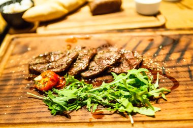 Dilimlenmiş kuzu kızartma ve roka ile bir gemide yalan.