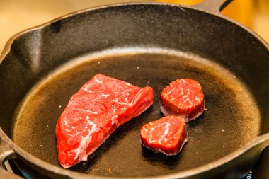 Bir tavada birkaç mermer sığır eti dilim kızarmış.