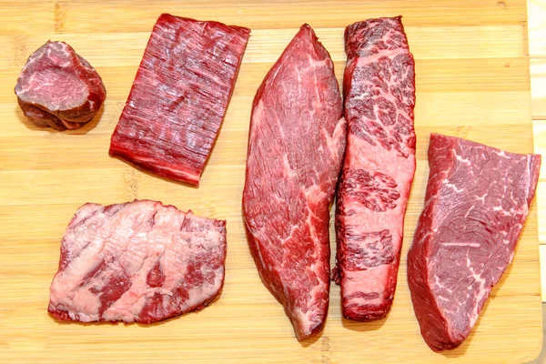 Viele verschiedene Steaks von marmoriertem Rindfleisch liegen auf dem Brett, Rippe — Stockfoto