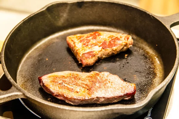 Несколько ломтиков мраморной говядины поджариваются на сковороде. . — стоковое фото