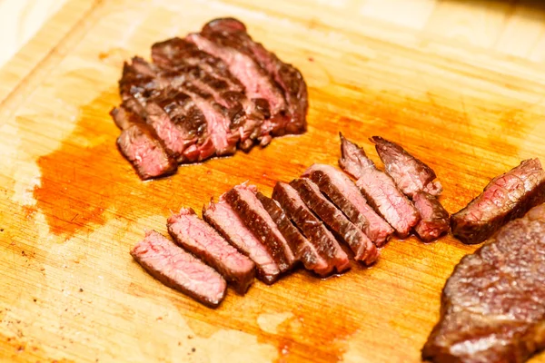 De chef-kok snijdt biefstuk roosteren zeldzame. — Stockfoto