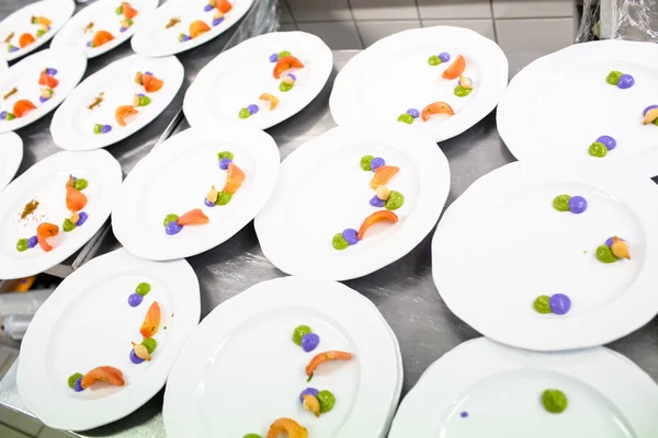 Cozinheiro decora um prato de comida com molho verde — Fotografia de Stock