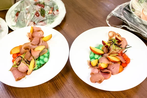 Pêssegos Prosciutto e outros frutos deitados em um prato . — Fotografia de Stock