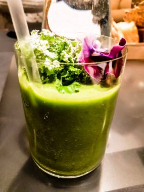 Taze çiçeklerle süslenmiş yeşil smoothie