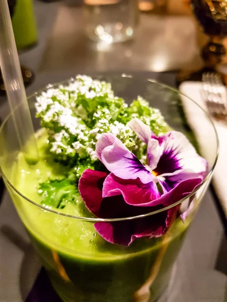 Zelené smoothie vyzdobené čerstvými květinami — Stock fotografie