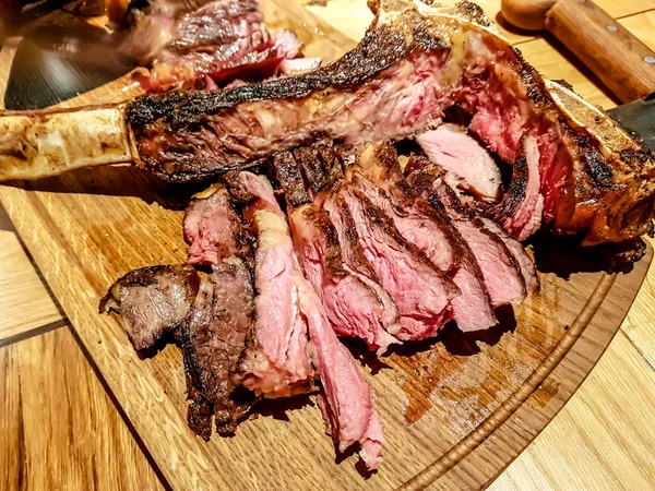 Şef dilim kızarmış et, antrikot biftek kemik üzerinde keser — Stok fotoğraf