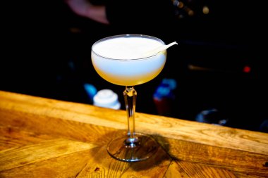 Masanın üzerinde köpüklü sarı kokteyl var.