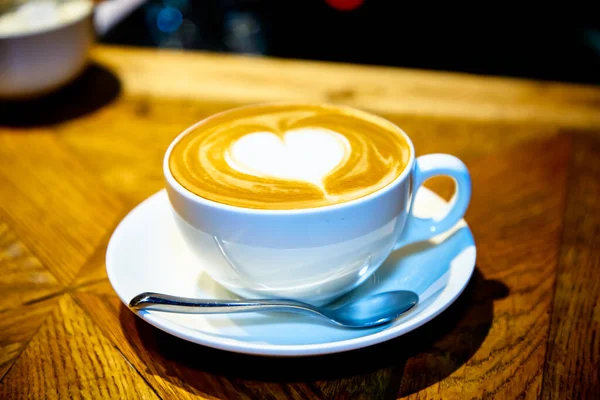 Heart on a cappuccino Cup on a wooden table Stock Picture