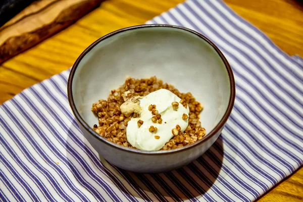 Porridge di grano saraceno con funghi e panna acida è nel piatto — Foto Stock