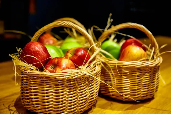 Червоні і зелені яблука в маленькому кошику — стокове фото