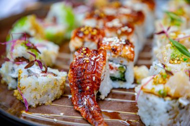 Farklı Japon dürümleri ve bir tabakta suşi. Yılanbalığıyla yuvarlan.