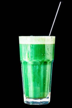 Bitki ve sebzelerden yapılmış yeşil smoothie siyah bir zemin üzerinde büyük cam bir bardak, izole