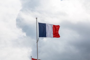 Bulutlu mavi gökyüzüne karşı Fransa bayrağı.