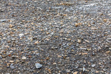 Toprak küçük granit taşlarla kaplı. Arkaplan için kullanılabilir.