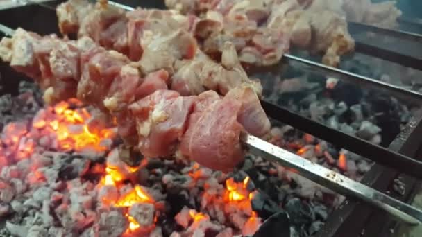 De kok bereidt een barbecue op spies op de grill over hete kolen — Stockvideo