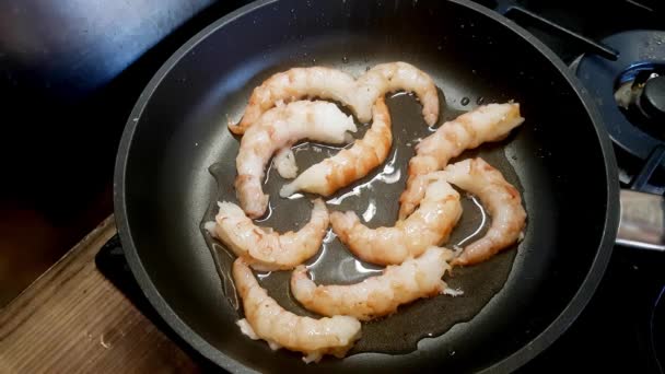 Le cuisinier fait frire des crevettes dans une poêle — Video
