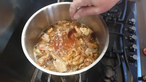 Beredning av bisksås. Tomatpuré tillsätts buljong med räkor och blandad — Stockvideo