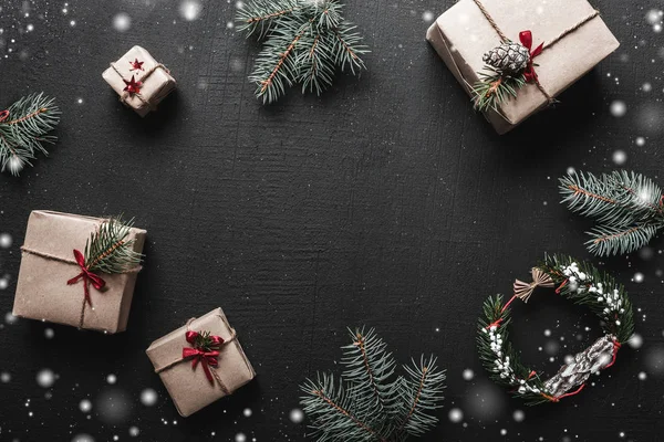 Kerst samenstelling. De giften van Kerstmis of Nieuwjaar en Spar twijgen op een zwarte achtergrond. Kopiëren van ruimte, plat lag. — Stockfoto