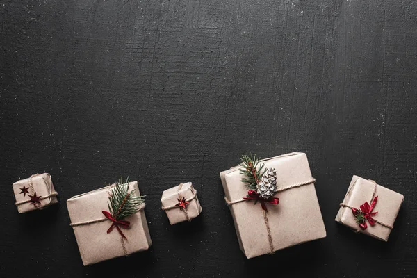 Creatieve hobby. Verpakking van moderne kerstcadeau selectievakjes in stijlvolle bruine papieren met lint. Bovenaanzicht van geschenken, decoratie elegantie. — Stockfoto