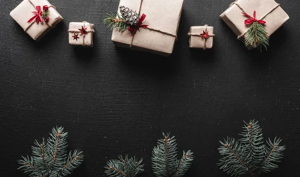 Kerstkaart. Symmetrisch gerangschikt geschenken bij de boven- en groene fir takken aan de onderkant van de afbeelding. Ruimte voor groet kerstboodschap — Stockfoto