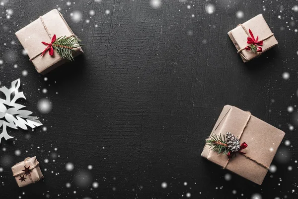 Kerstkaart. Geschenken gerangschikt symmetrisch, door de hoeken, voor ruimte in het midden voor een kerstboodschap voor de groet, de aangename sfeer met sneeuwvlokken — Stockfoto
