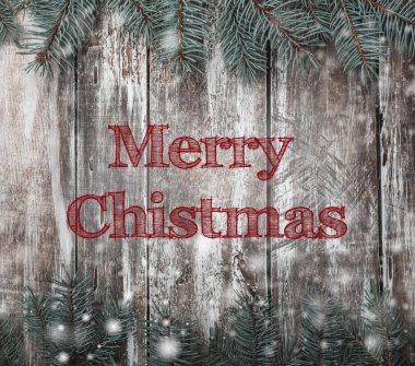 Ahşap yüzey beyaz boya ve çam dalları tonlarında.