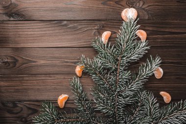 Kahverengi ahşap arka plan. Köknar ağacı çam ağacı, mandalina dilimleri ile süslenmiş. Noel tebrik kartı ve yeni yıl. Noel ve mutlu yeni yıl kompozisyon.