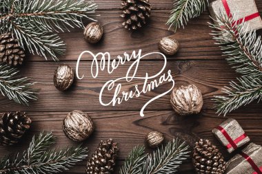 Kahverengi ahşap arka plan. Çam dalları, çam kozalakları ve dekoratif ceviz. xmas hediyesi. Noel tebrik kartı ve yeni yıl. Noel ve mutlu yeni yıl kompozisyon.