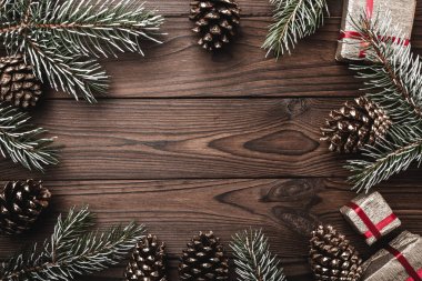 Kahverengi ahşap arka plan. Çam dalları, dekoratif koniler. İleti alanına Noel ve yeni yıl için. Xmas hediyesi. Tebrik kartı. Noel ve mutlu yeni yıl kompozisyon.