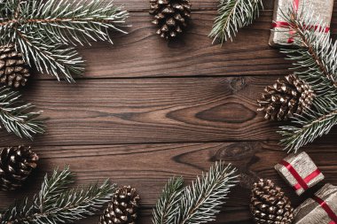 Kahverengi ahşap arka plan. Çam dalları, dekoratif koniler. İletiyi alan. Xmas hediyesi. Noel tebrik kartı ve yeni yıl.