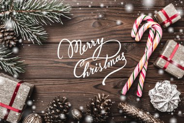 Ahşap arka plan. Çam ağacı, dekoratif koni. İleti alanına Noel ve yeni yıl için. Tatlılar ve tatil için hediyeler. renkli şekerler. Kar taneleri.