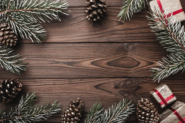 Fundo de madeira marrom. Ramos de abeto, cones de abeto decorativos. presentes para o Natal. Cartão de Natal e Ano Novo . — Fotografia de Stock