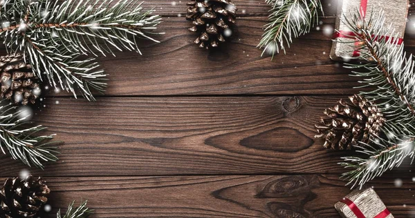 Kahverengi ahşap arka plan. Çam dalları, dekoratif koniler. İletiyi alan. Xmas hediyesi. Noel tebrik kartı ve yeni yıl.