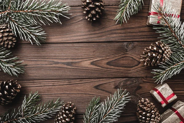 Fundo de madeira marrom. Ramos de abeto, cones decorativos. Espaço para a mensagem. Presentes para o Natal. Cartão de Natal e Ano Novo . — Fotografia de Stock