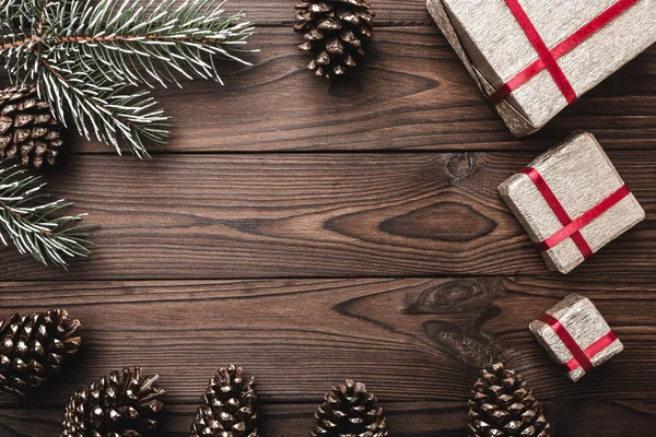 Kahverengi ahşap arka plan. Çam ağacı, dekoratif koniler. İleti alanına Noel ve yeni yıl için. Xmas için hediyeler.