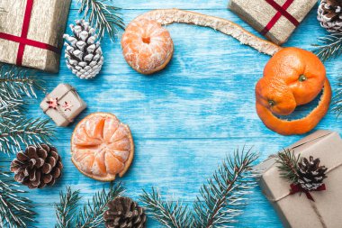 Azure ahşap arka plan. Yeşil çam dalları, konsensüs Noel tebrik kartı ve yeni yıl. Noel Baba'nın mesaj için alan. Mandalina. Tatil. Hediyeler.