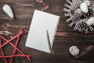 Kahverengi ahşap arka plan doku ile. Koniler ve dekoratif ceviz. Noel Baba'nın mesaj ve tatil mektup. Kızıl Yıldız. Tatil kartı. Noel ve mutlu yeni yıl kompozisyon. Düz yatıyordu, en iyi görünümü