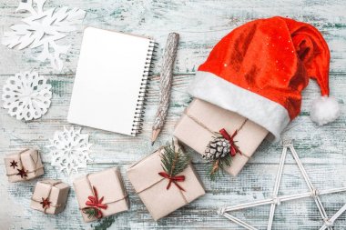 Eski ahşap beyaz arka plan. Noel Baba'ya gidelim. Noel tebrik kartı, el yapımı öğeleri. Birçok hediyeler sanatsal düzenlenmiştir. Onun Noel Baba'nın şapka. Noel ve mutlu yeni yıl kompozisyon. Düz yatıyordu, en iyi görünümü