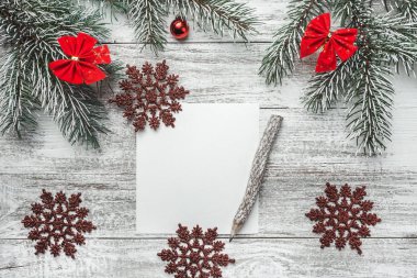 Noel, yeni yıl mektup, kart yazma, rustik bir arka plan üzerinde eski stil kalem ve evergreen, kar tanesi, şerit süs eşyaları ile üst bir bakış