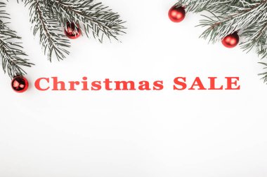 Herdem yeşil dallar ve ağacı oyuncaklar süslemeleri, üst, üst görünümü ile beyaz arka plan üzerinde Noel satışı büyük başlığı. 