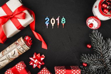 Siyah arka plan, 2018 sayı mum ile kırmızı kurdele, mevcut üst üstten görünüm, el yapımı Noel oyuncak ve bir taş üzerinde evergreen şube
