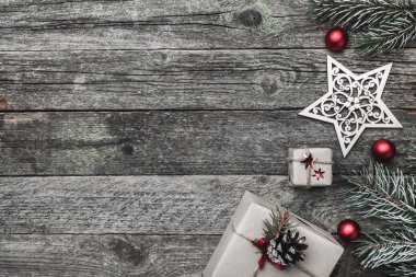 Üst, üst, yukarıdan bakış beyaz kış figürinler, herdem yeşil dal, kırmızı oyuncaklar ve yazma, tebrik metin için yer ile gri arka plan üzerinde sunar