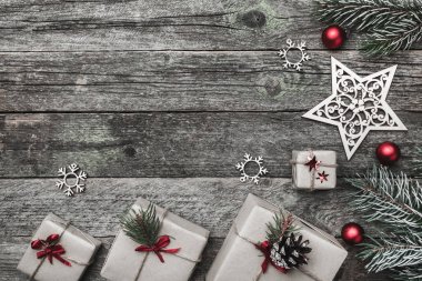 Üst, üst, görüntülemek üzerinden yukarıda beyaz kış figürinler, herdem yeşil dal, kırmızı oyuncak, hediyeler ve yazma, tebrik metin için yer ile gri arka plan üzerinde mutlu Noeller yazıt