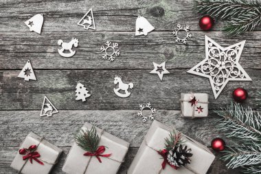 Üst, üst, görüntülemek üzerinden yukarıda beyaz kış figürinler, yaprak dökmeyen şube, kırmızı oyuncak, hediyeler ve gri arka plan, kitabe Merry Christmas tebrik