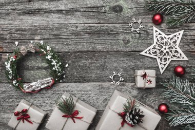 Üst, üst, görüntülemek üzerinden yukarıda beyaz kış figürinler, herdem yeşil dal, kırmızı oyuncak, hediyeler ve yazma, tebrik metin için yer ile gri arka plan üzerinde mutlu Noeller yazıt