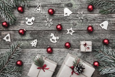 Üst, üst, görüntülemek üzerinden yukarıda beyaz kış figürinler, yaprak dökmeyen şube, kırmızı oyuncak, hediyeler ve gri arka plan, kitabe Merry Christmas tebrik