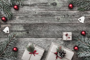 Üst, üst, görüntülemek üzerinden yukarıda beyaz kış figürinler, herdem yeşil dal, kırmızı oyuncak, hediyeler ve yazma, tebrik metin için yer ile gri arka plan üzerinde mutlu Noeller yazıt